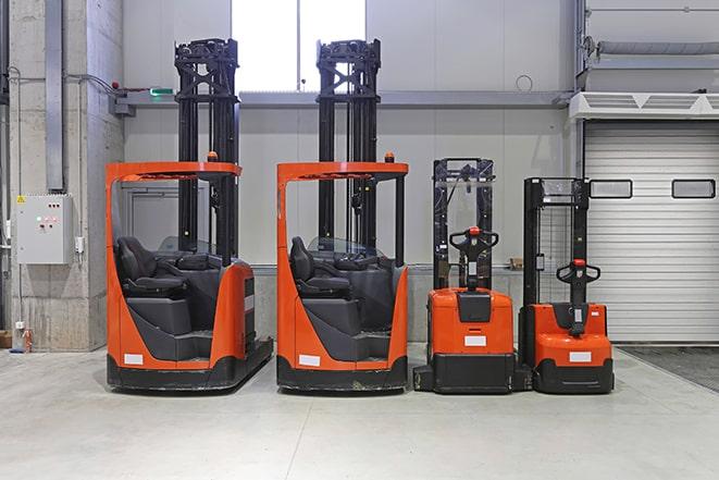 forklifts lifting heavy machinery